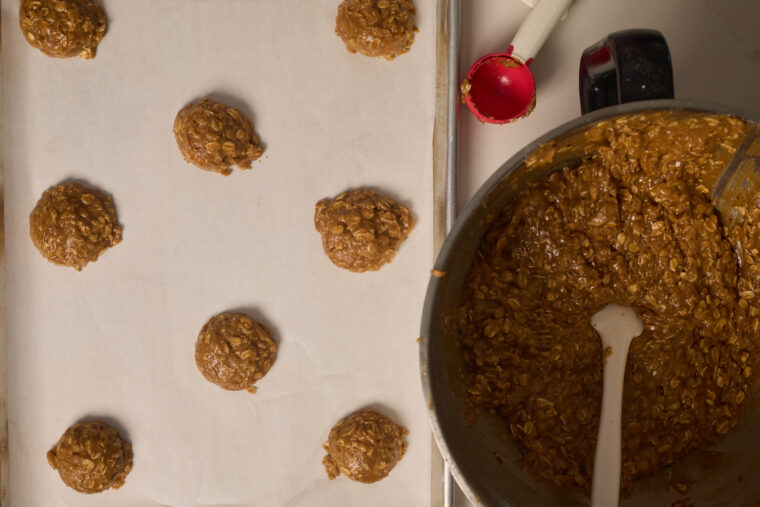 scooping browned butter oatmeal cookie dough onto cookie sheets