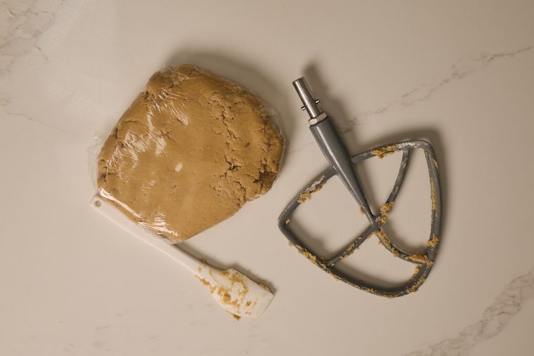 maple brown sugar cookie dough wrapped in plastic wrap next to the beater