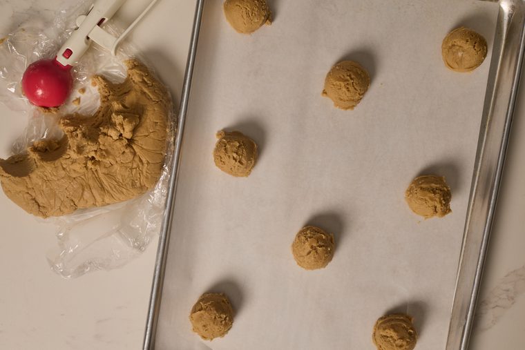 scooped cookie dough on a cookie sheet lined with parchment paper.