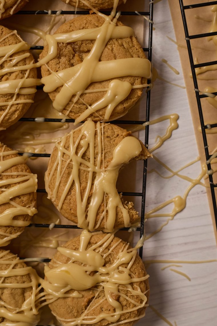 maple brown sugar cookies sitting on a cooling rack with a bite taken out