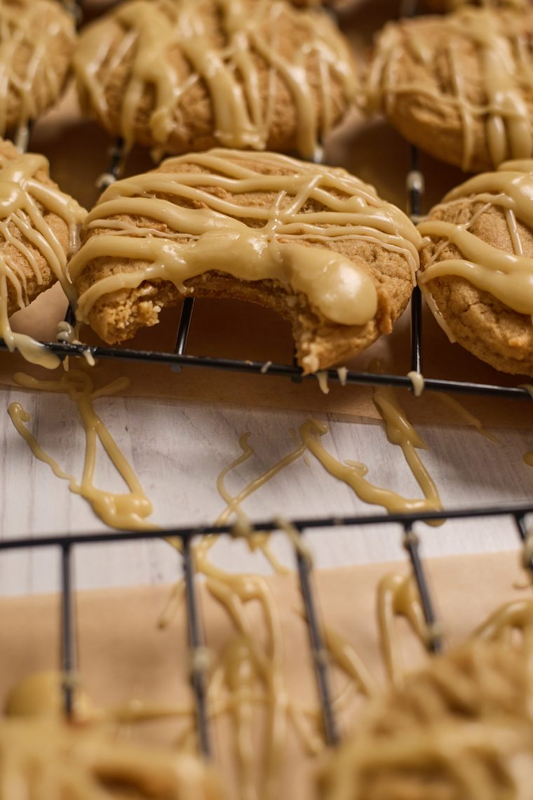 maple brown sugar cookies sitting on a cooling rack with a bite taken out
