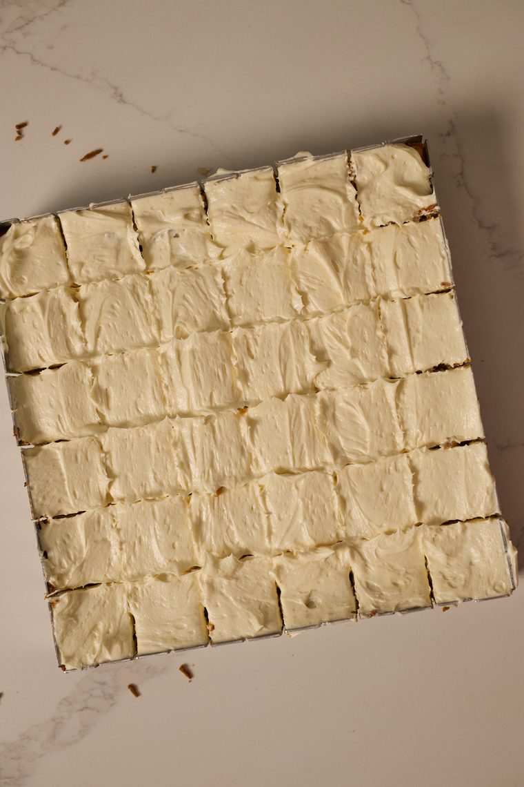 A pan of pumpkin bars covered with cream cheese frosting and cut into squares.