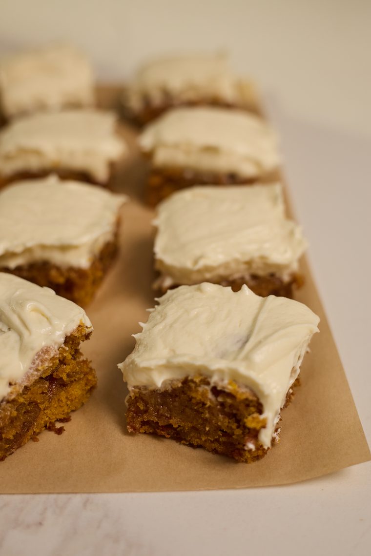 Close-up of pumpkin bars with a thick layer of cream cheese frosting.