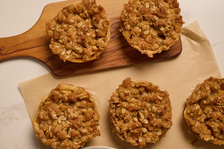 mini dutch apple pies on a parchment and wooden board