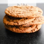 A bunch of soft and chewy molasses cookies are chilling on a dark background. Up top, theres some text that says Soft and Chewy Molasses Cookies Recipe.
