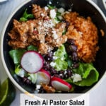 A bowl loaded with al pastor-seasoned meat, Mexican rice, black beans, lettuce, radish slices, and crumbled cheese. Surrounded by lime and other tasty sides. Text says: “Fresh Al Pastor Salad Recipe—dig into this vibrant salad!”.