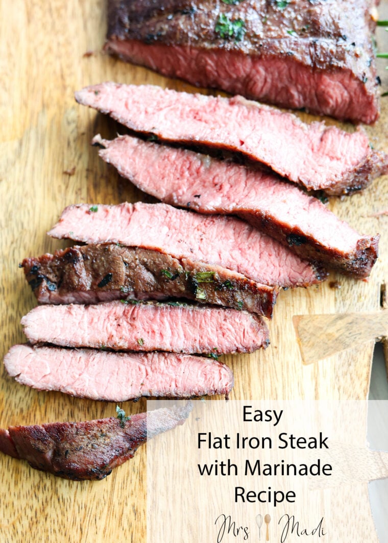 Juicy, medium-rare flat iron steak sliced up on a wooden cutting board. Text says: Easy Flat Iron Steak with Marinade Recipe by Mrs. Madi.