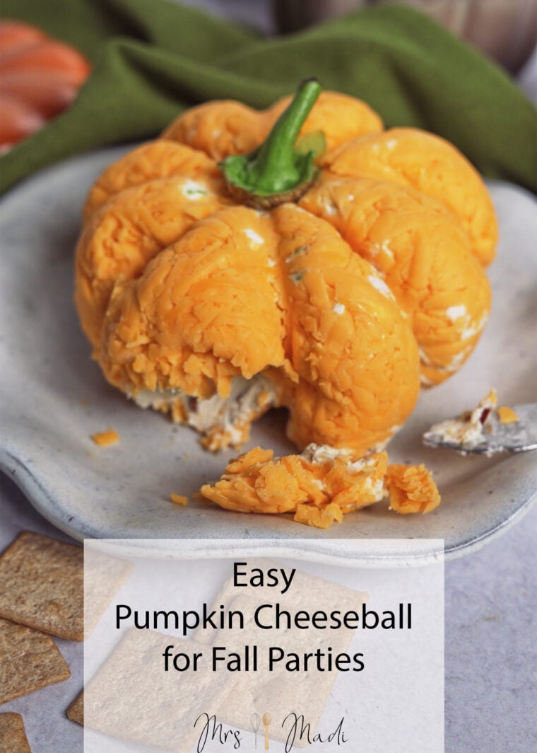 Partially eaten pumpkin-shaped cheeseball on a plate with a cracker and knife. Text: Easy Pumpkin Cheeseball for Fall Parties.