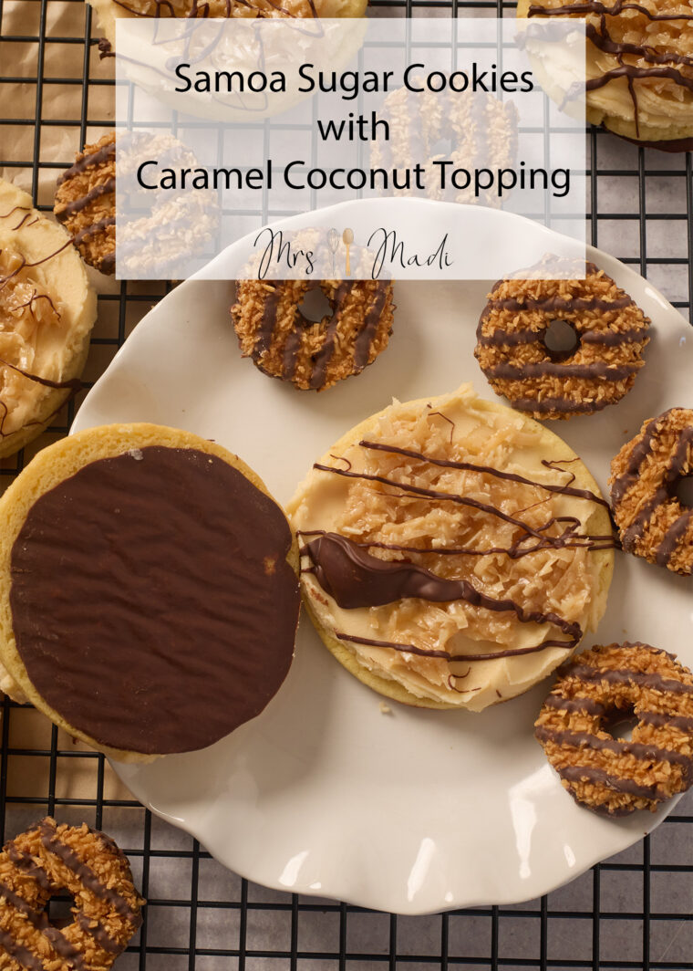 Big samoa sugar cookies with caramel, coconut, and chocolate drizzle on a plate, with mini ones around them on a cooling rack.