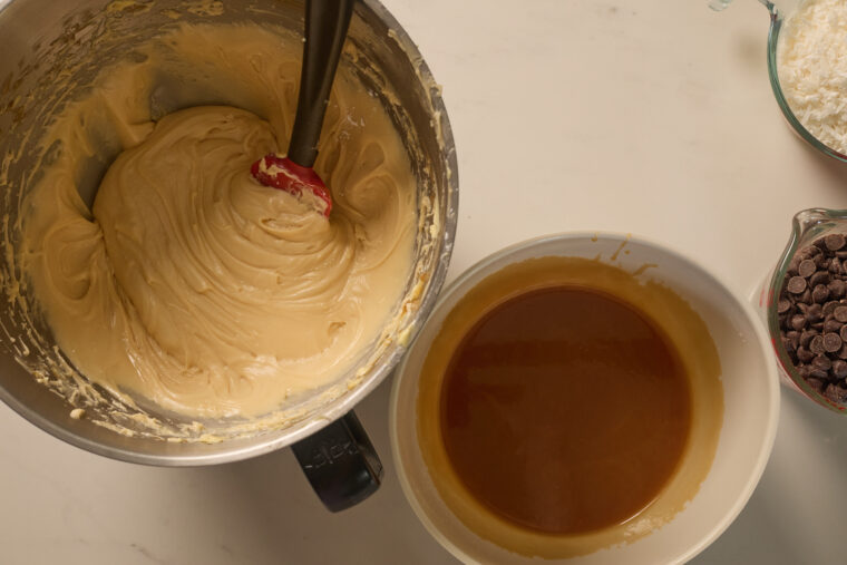 There&rsquo;s a bowl of thick samoa cookie batter, plus caramel sauce, chocolate chips, and shredded coconut all on a light countertop.