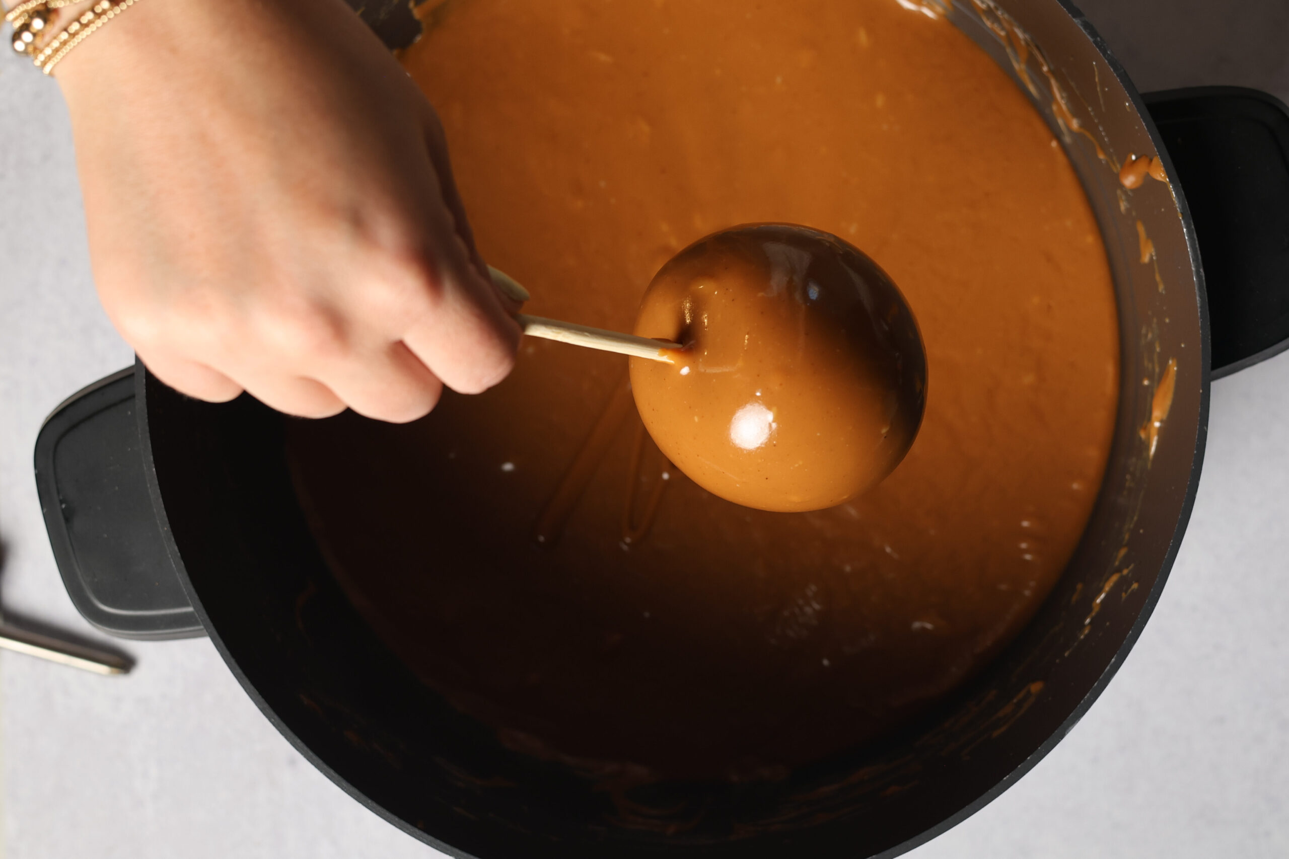 Someone&rsquo;s dunking an apple on a stick into gooey caramel, making some seriously tasty caramel apples.