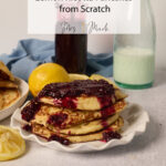 Fluffy Lemon Ricotta Pancakes with berry sauce on a plate, lemons and milk nearby. Text: Zesty Pancakes from Scratch.