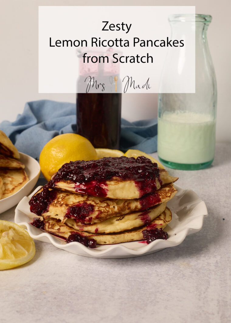 Fluffy Lemon Ricotta Pancakes with berry sauce on a plate, lemons and milk nearby. Text: Zesty Pancakes from Scratch.