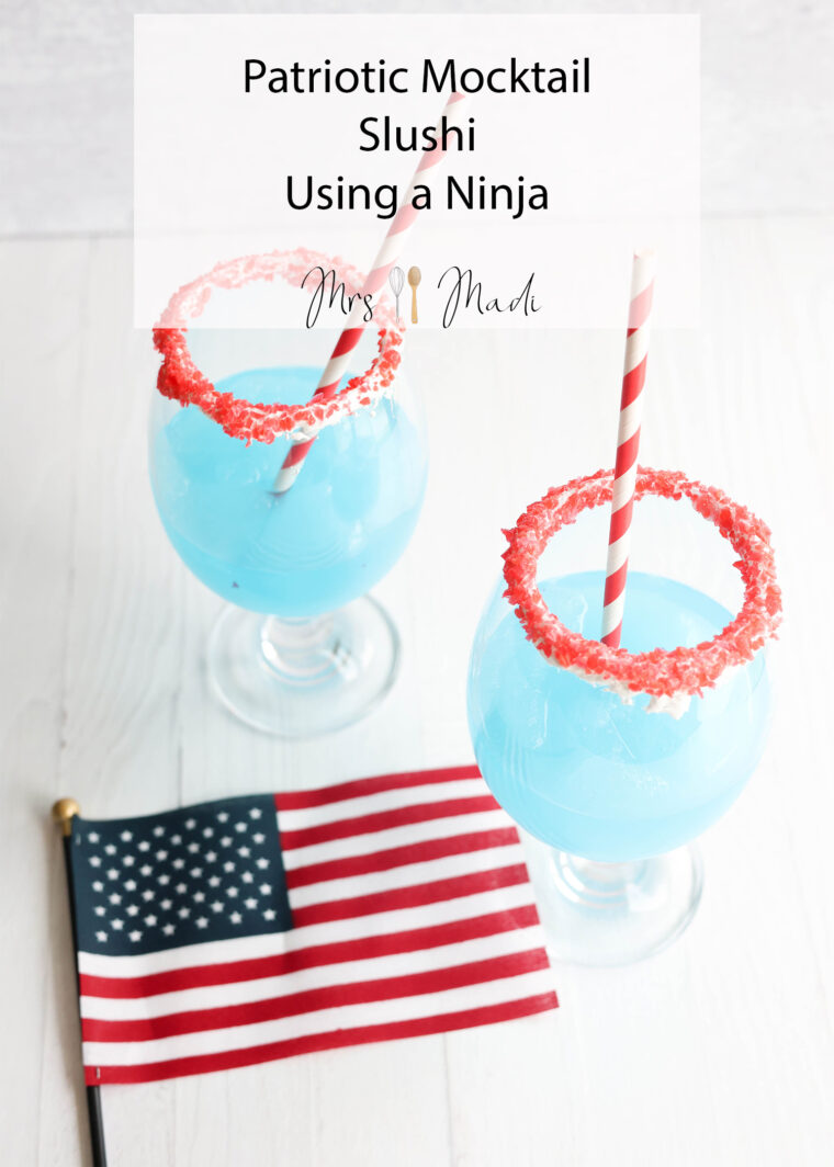 Two blue slushi mocktails with red sugar rims and striped straws sit by a tiny American flag. Text says: Patriotic Slushi Mocktail Using a Ninja.