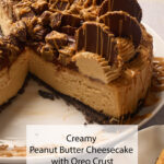 A rich peanut butter cheesecake with an Oreo crust, loaded with PB cups and drizzle, sits on a plate missing a slice.