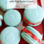 Blue rocket pop macarons with red and white Pop Rocks inside, lined up on a red tray. Text says: Rocket Pop Macarons with Pop Rocks Crunch.