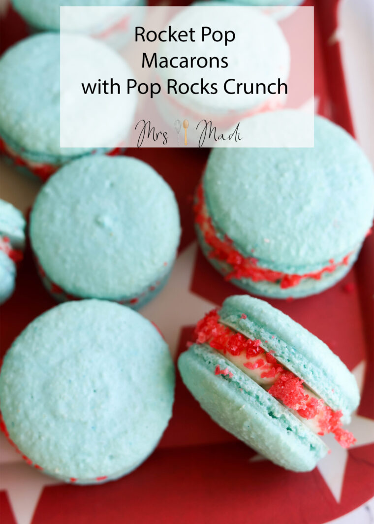 Blue rocket pop macarons with red and white Pop Rocks inside, lined up on a red tray. Text says: Rocket Pop Macarons with Pop Rocks Crunch.