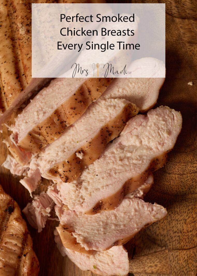 Juicy, perfectly seasoned smoked chicken breast slices sit on a board, with recipe text for the best smoked chicken ever.