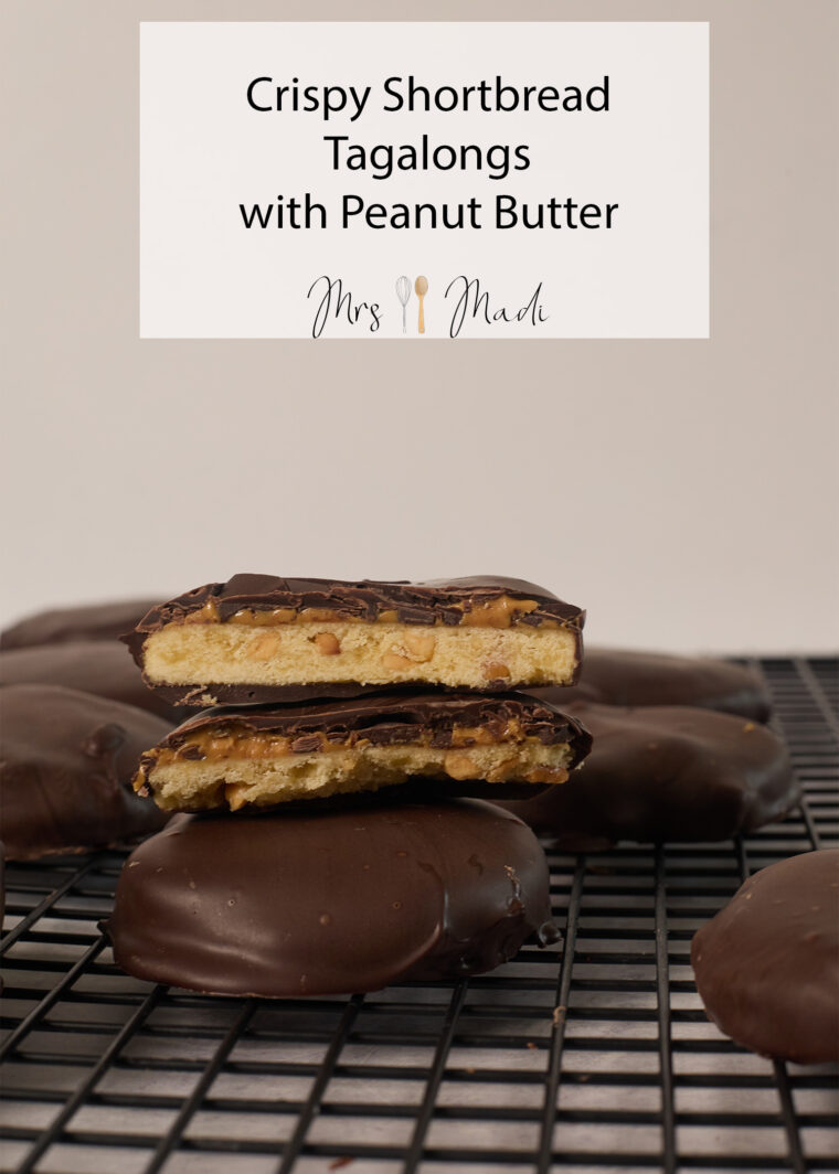 A bunch of chocolate-dipped shortbread cookies chill on a rack; one&rsquo;s split open to show its peanut butter center.