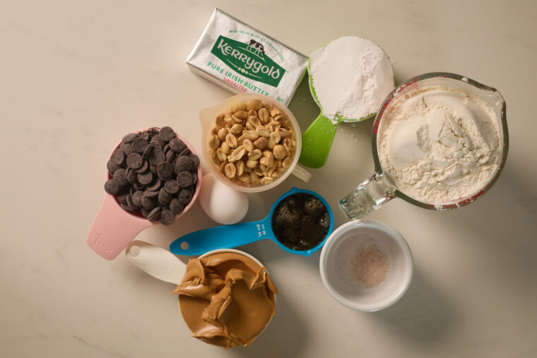 Peanut butter, chocolate chips, peanuts, and baking basics set out in bowls&mdash;ready for homemade Tagalongs or peanut butter treats.