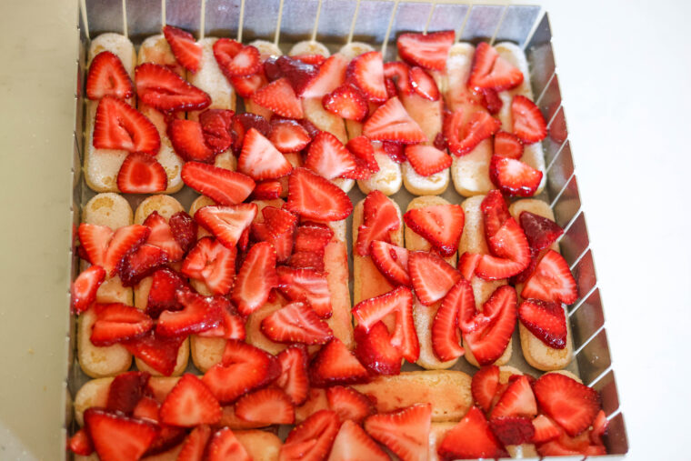 A square metal pan packed with ladyfinger cookies and topped with a layer of fresh sliced strawberries—these No-Bake Strawberry Shortcake Icebox Bars look super easy and are perfect for any get-together.
