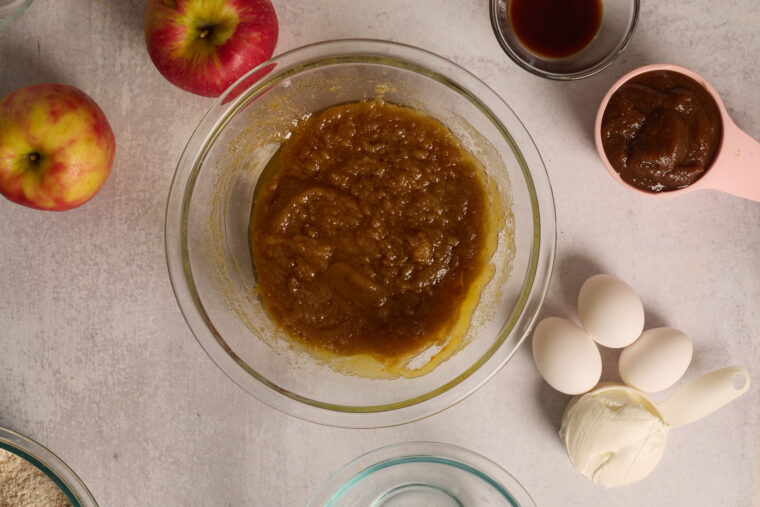 Melted butter mixed with brown sugar in a glass bowl for apple cake.