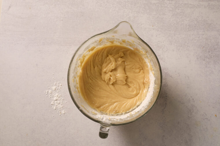 Smooth browned butter cream cheese frosting in a glass mixing bowl.