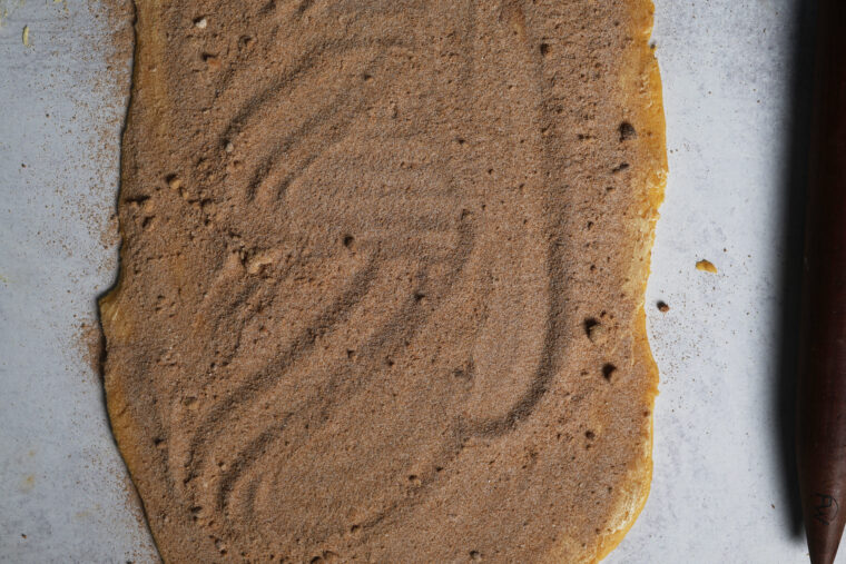 rolled out pumpkin cinnamon roll dough with filling spread on top